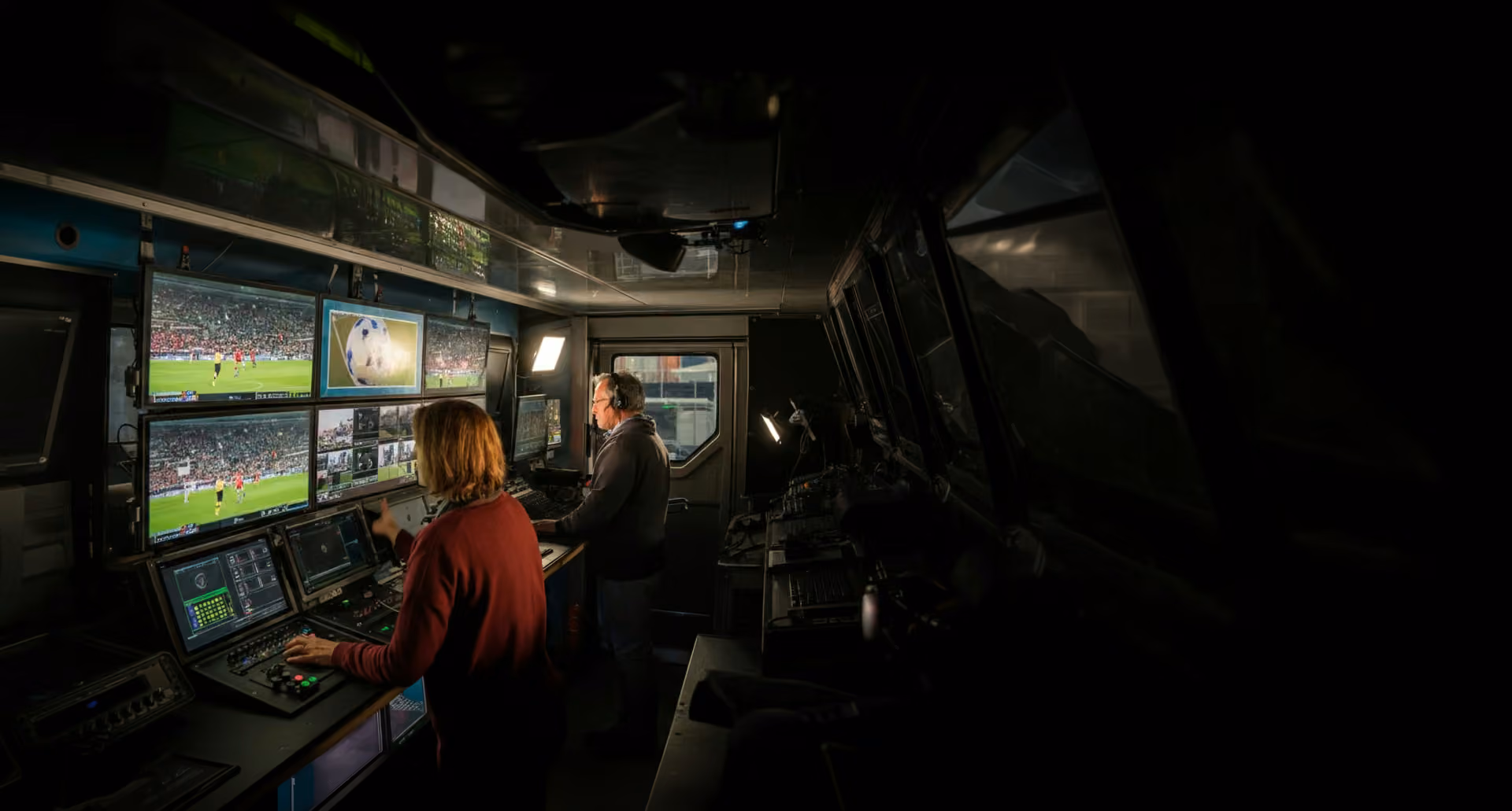 Broadcast operators at a control desk in an outside broadcast truck